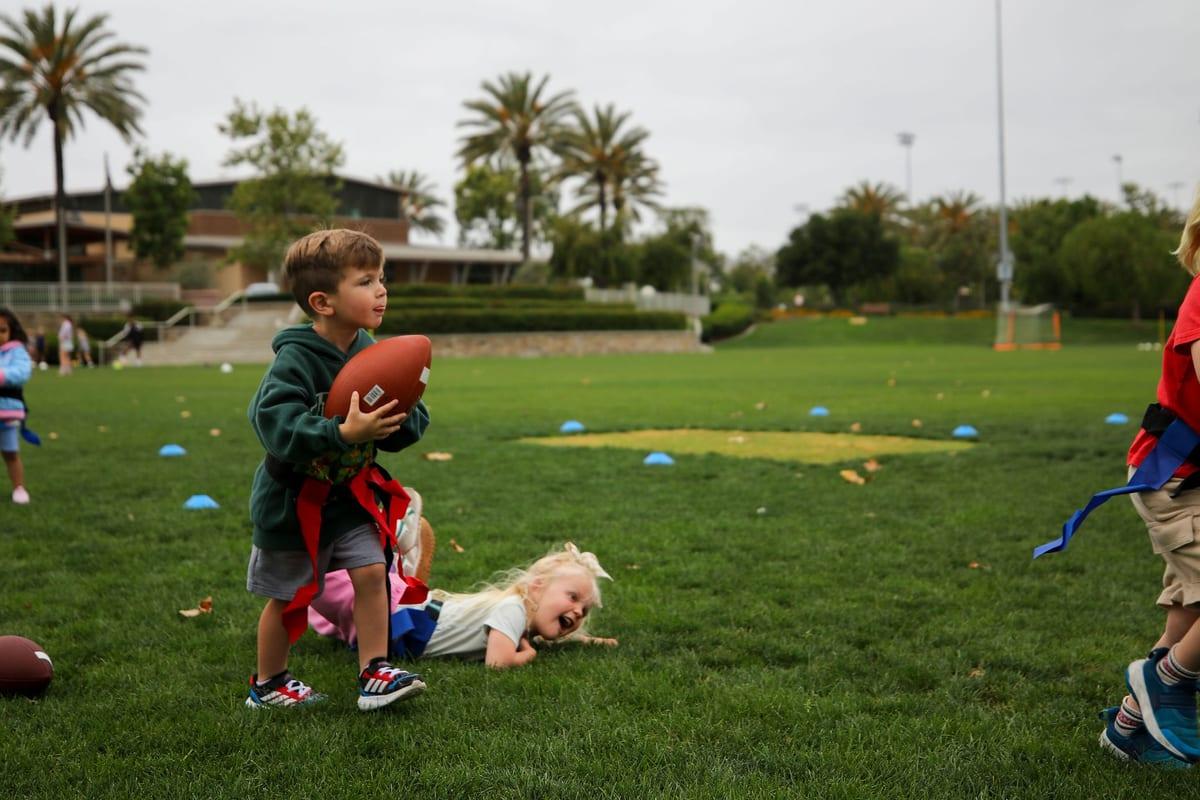 A young athlete running with the ball during an AFC Foundations class