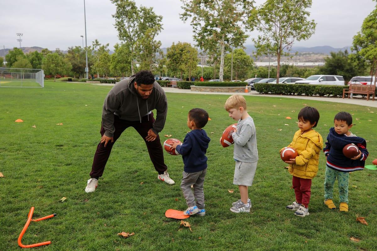 Coach Mike coaching young athletes on the field in Orange County