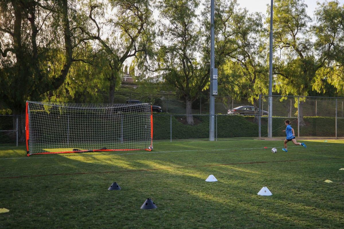 An AFC athlete striking on goal at golden hour during a Performance session