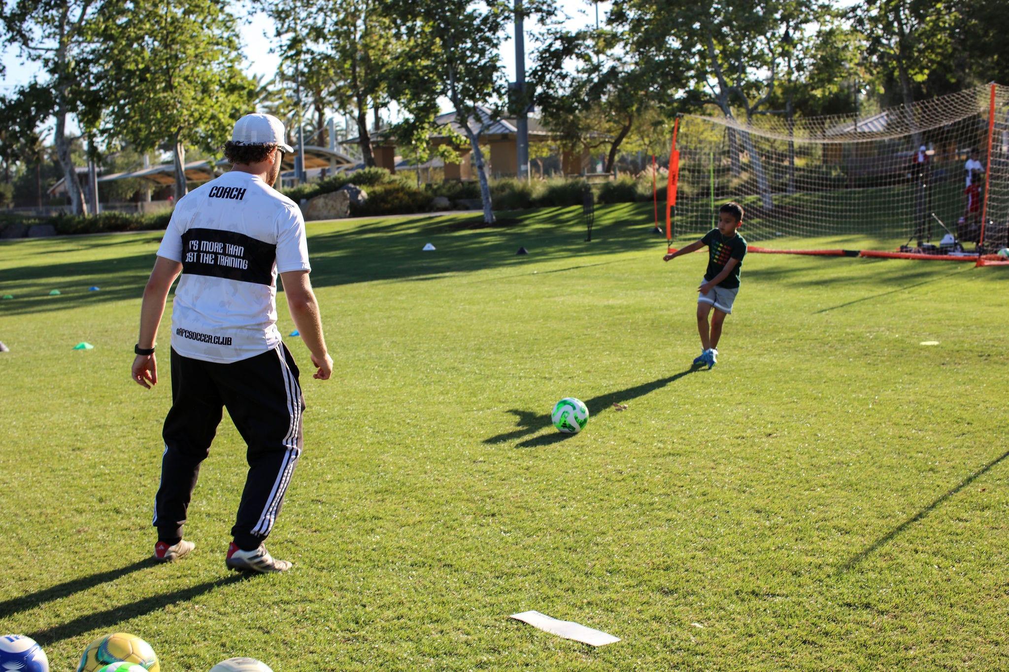 AFC coach guiding a young athlete through a finishing rep at golden hour