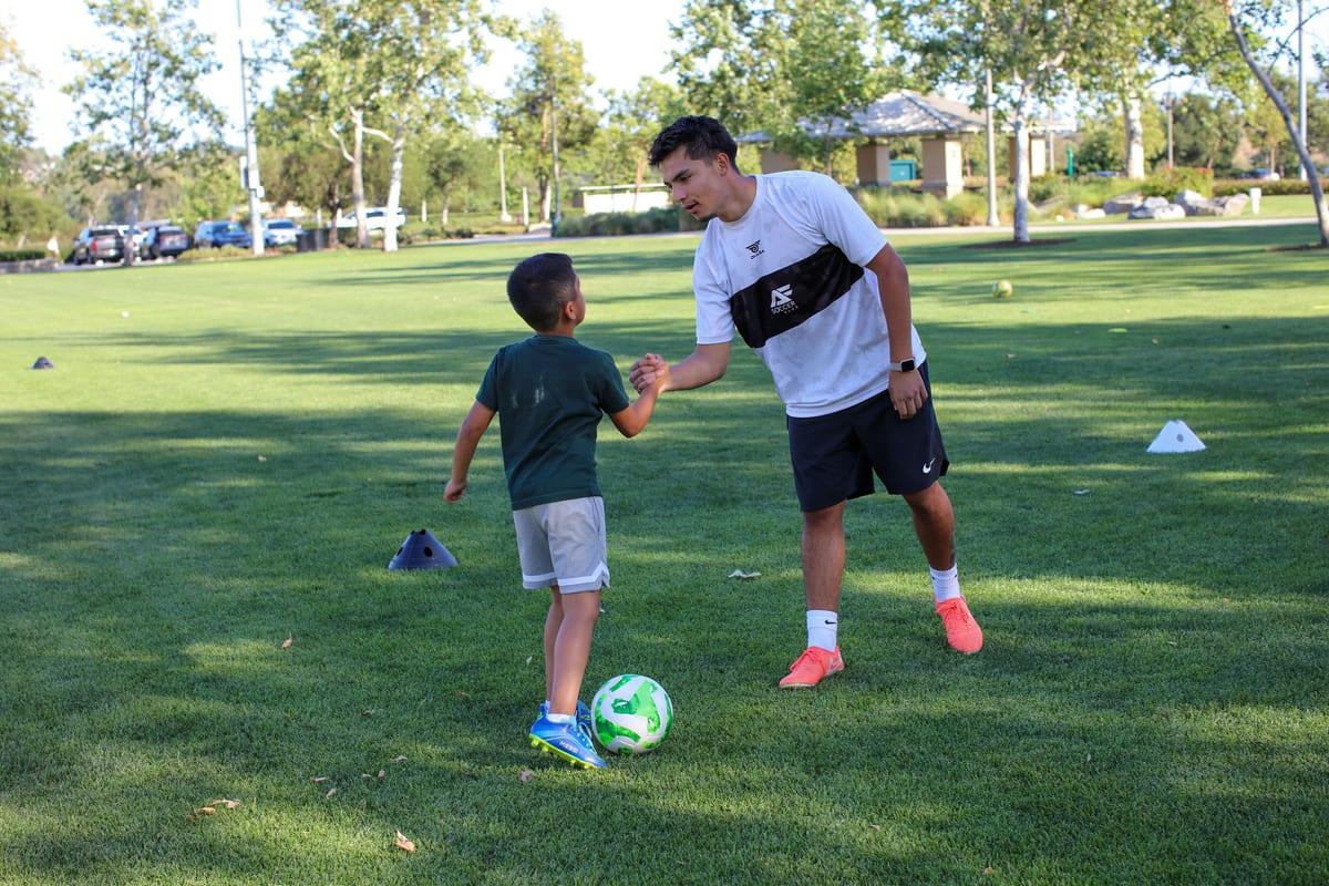 AFC coach Sebass connecting with a young athlete on the field