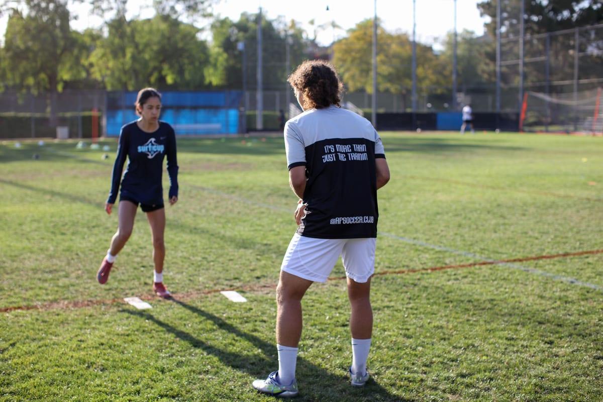 An AFC coach running a sprint drill with a young athlete