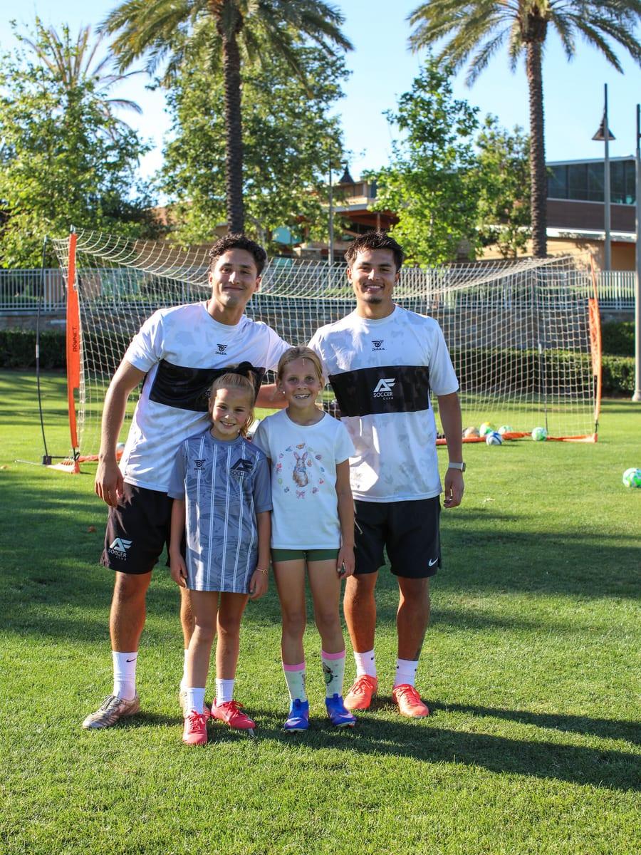AFC coaches Andre and Sebass with two young athletes at the park